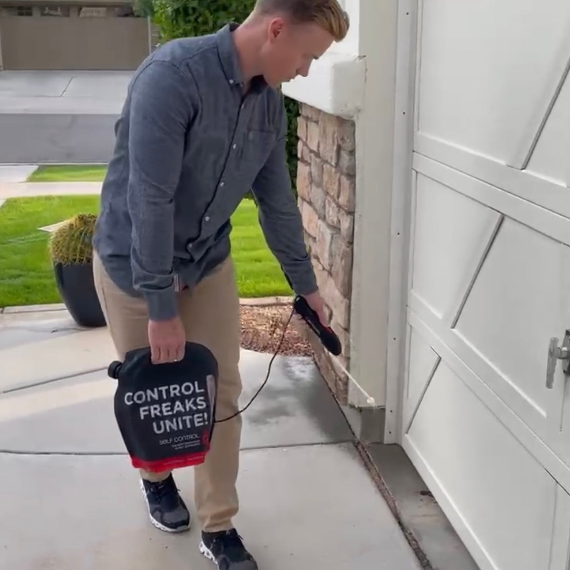 Person wearing yellow protective suit while spraying pesticide to a potted plant