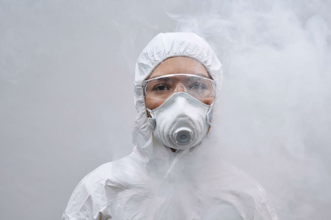 Pest chemical spray smoke surrounding a person wearing a white protective suit